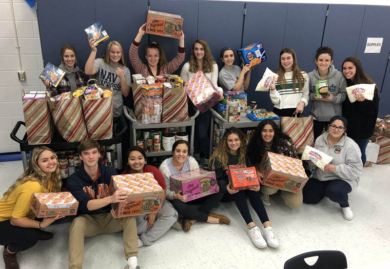 Students displaying food that was donated to the food drive