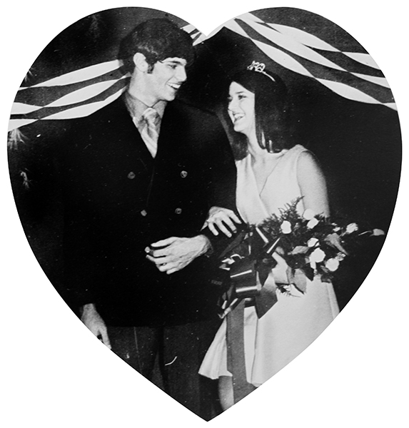 The homecoming king and queen from the 1970 annual homecoming dance pose with their flowers. The photograph is heart-shaped.