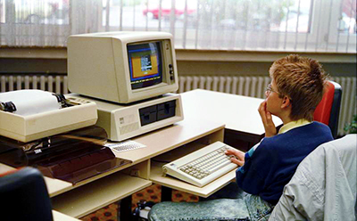 Photograph of a student using an IBM 5153 computer.